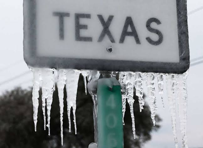 A road sign that says 'Texas' has long icicles hanging from it, demonstrating the unusual winter conditions part of the state experienced in February 2021.